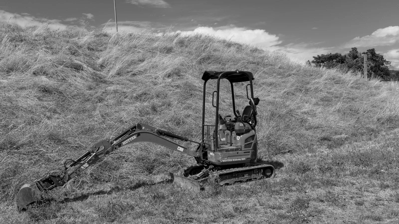 Compact excavator digging a foundation trench in red Georgia clay