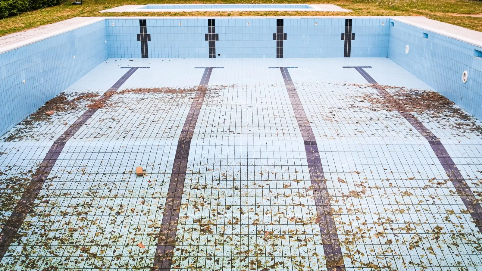 Empty inground swimming pool being prepared for demolition and removal in a metro Atlanta back yard